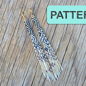 May include: A pair of long, dangling earrings featuring a woven bead design with a chevron pattern at the top, transitioning into a gradient of black, white, and metallic gold beads. The earrings have gold-tone lever-back hooks and the word PATTERN.