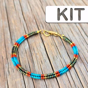 Könnte beinhalten: Ein Perlenarmband-Set mit türkisfarbenen, orangefarbenen und goldenen Perlen. Das Armband liegt auf einer Holzoberfläche mit dem Wort "KIT" in weißer Schrift auf grauem Hintergrund.