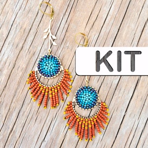 May include: A pair of beaded earrings with a blue and turquoise center circle, surrounded by orange and yellow beads. The earrings are hanging from gold-colored hooks with a small leaf design. The word "KIT" is written on a white background.