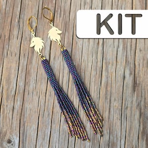 May include: Dangle earrings featuring gold-coloured wolf head charms and beaded tassels. The tassels transition from dark blue to gold. The word "KIT" is in a white rectangle in the background.