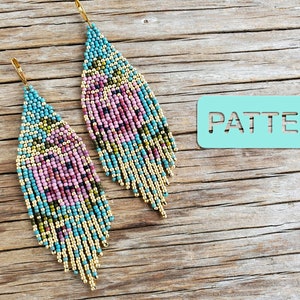 May include: A pair of long, beaded earrings with a floral pattern in shades of pink, teal, gold, and brown. The earrings are hanging from gold hooks.