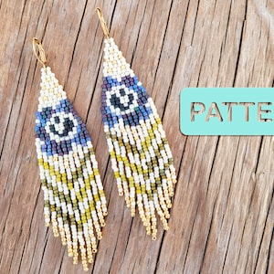 May include: A pair of long, beaded earrings with a geometric pattern in shades of white, gold, green, blue, and purple. The earrings have a fringe of gold beads at the bottom. The word "PATTERN" is written on a teal blue sign.