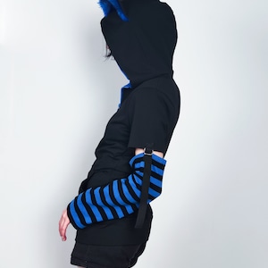 Puede incluir: Una sudadera con capucha negra con orejas de piel azul y mangas a rayas azules y negras.