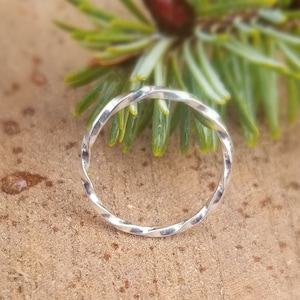 May include: A silver twisted ring with a hammered finish. The ring is simple and delicate, and would make a great everyday piece of jewellery.