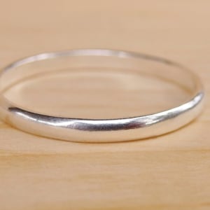 May include: A simple silver band ring with a smooth, polished finish.