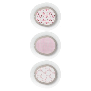 May include: Three adhesive bandages with different pink and white patterned designs. The designs include cherries, gingham, and bows.