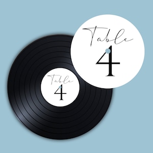 May include: A black vinyl record with a white circle label that says "Table 4" in black script. There is a second white circle label with the same text on a white background.