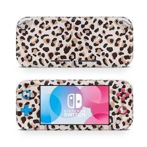 May include: A leopard print Nintendo Switch Lite console with a pink and blue screen and pink buttons. The console has a white border and the Nintendo Switch logo is visible on the screen.
