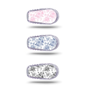 Könnte beinhalten: Drei verschiedene Musterdesigns für ein medizinisches Gerät. Die Designs sind floral und zeigen rosa, blaue und schwarze Farben auf weißem Hintergrund.