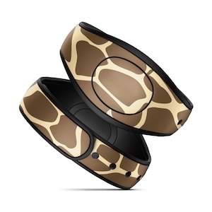 May include: A pair of brown and tan MagicBand wristbands with a giraffe print design.