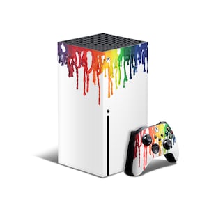 Op de afbeelding: Witte Xbox Series X console met een regenboogkleurig verfspat-ontwerp. De console wordt getoond met een bijpassende Xbox-controller met een regenboogkleurig verfspat-ontwerp.