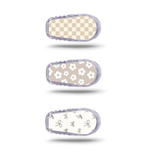 Könnte beinhalten: Drei verschiedene Designs für eine medizinische Geräte-Hautverkleidung. Das erste Design ist ein beige-weißes Karomuster. Das zweite Design ist ein beiger Hintergrund mit weißen Blumen. Das dritte Design ist ein weißer Hintergrund mit braunen Schleifen.