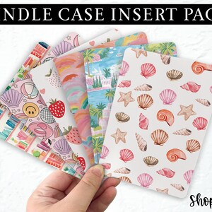 May include: A set of five rectangular Kindle case inserts featuring various patterns including seashells, tropical landscapes, rainbows, strawberries, and beach-themed icons like smiley faces and disco balls, all displayed in a fan-like arrangement.