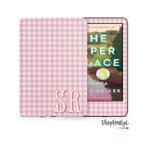 May include: Pink and white gingham patterned e-reader cover with the initials "SR" in a script font. The e-reader displays the cover of "The Paper Place" by Randa Heller, a Reese's Book Club selection.