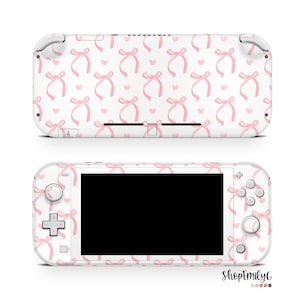 May include: White Nintendo Switch Lite console with a pink and white bow pattern skin. The console has a black screen and pink buttons.