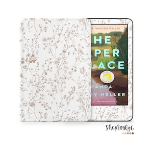 May include: A white Kindle Paperwhite e-reader with a floral pattern case. The screen displays the cover of the book "The Paper Palace" by Miranda Cowley Heller.