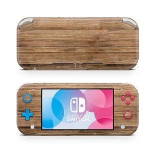 May include: A Nintendo Switch Lite console with a wood grain skin. The console has a blue and pink screen with the Nintendo Switch logo and text. The buttons are blue, pink, and red.
