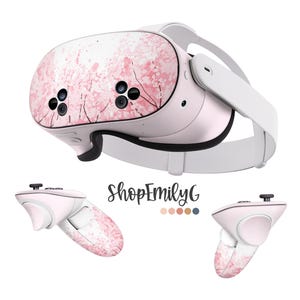 May include: A pink and white VR headset with a floral design. The headset has two controllers with the same floral design. The text "ShopEmilyG" is visible in the image.