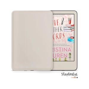Könnte beinhalten: Ein weißer Kindle E-Reader mit einer beigefarbenen Hülle. Der Bildschirm zeigt das Cover eines Buches mit dem Titel "Love & Other Words" von Christina Lauren. Das Cover zeigt eine Aquarell-Illustration einer Tasse Kaffee, Bücher und Bleistifte.