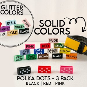May include: A set of three silicone watch bands with polka dots in black, red, and pink. The bands are shown on a white background with other watch band colours in the background.