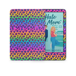 May include: A colorful e-reader case with a vibrant leopard print in shades of pink, purple, yellow, and blue. The screen displays a book cover with the title "Hate More" and an illustration of a woman.