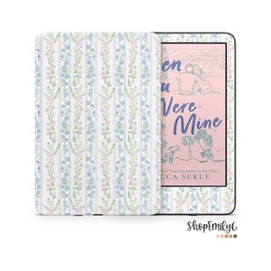 May include: A pink and white Kindle e-reader cover with a floral pattern. The cover is designed to fit the Kindle Paperwhite. The book cover on the Kindle is for the book "When You Were Mine" by Rebecca Serle.