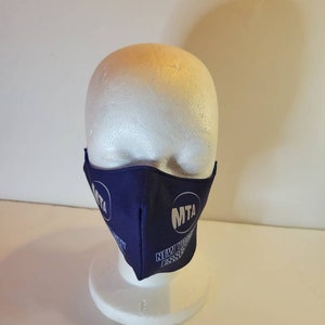 May include: A blue face mask with the MTA logo and the text "New York City Transit" in white.