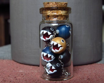 Figurines miniatures Chain Chomps en pâte polymère dans une bouteille en verre, inspirées de jeux vidéo.