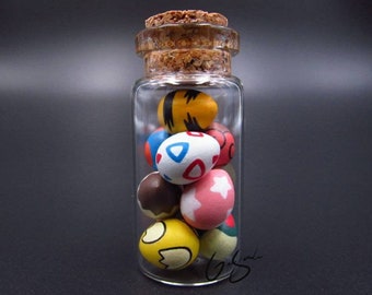 Pequeño frasco de vidrio con huevos de Pokémon, figuras de Pokémon en miniatura de arcilla polimérica en una botella, Pokémon en miniatura