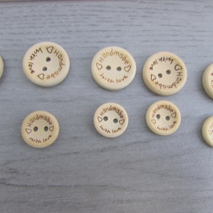 May include: Ten wooden buttons with two holes each. The buttons are light brown and have the text "Handmade with love" engraved on them.