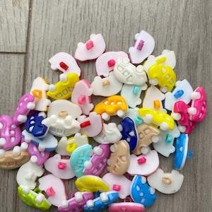 Peut inclure: Un ensemble de boutons en plastique colorés en forme de voitures. Les boutons sont de différentes couleurs, notamment jaune, bleu, rose, vert, blanc et marron.