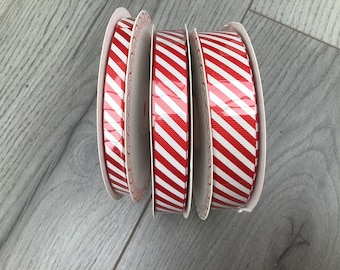May include: Four spools of red and white striped ribbon. The ribbon is on a white cardboard spool.