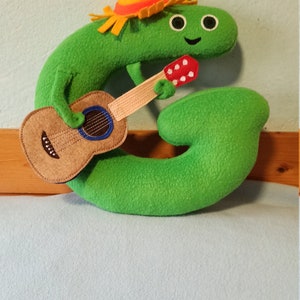 Brinquedo de pelúcia como Charlie e a letra do alfabeto ,,G ,,