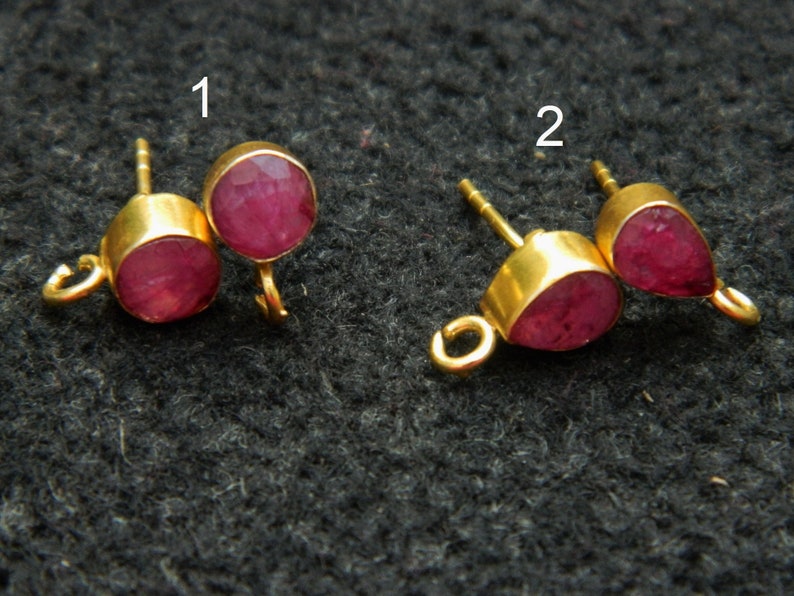 Pu&ograve; includere: Due paia di chiusure per orecchini dorati con accenti di pietre preziose rosse. Il primo paio presenta pietre preziose rotonde, mentre il secondo paio presenta pietre preziose a forma di goccia.