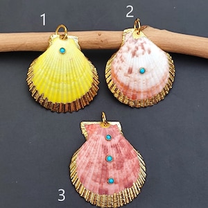 May include: Three gold-rimmed seashell pendants with turquoise stones. The shells are yellow, pink, and brown. The pendants are numbered 1, 2, and 3.