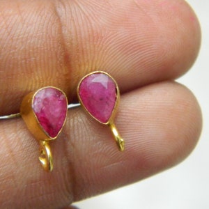 Pu&ograve; includere: Un paio di orecchini d'oro con pietre preziose rosa a forma di goccia.