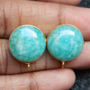 May include: A pair of gold earrings with green aventurine gemstones. The earrings are round and have a smooth, polished finish.