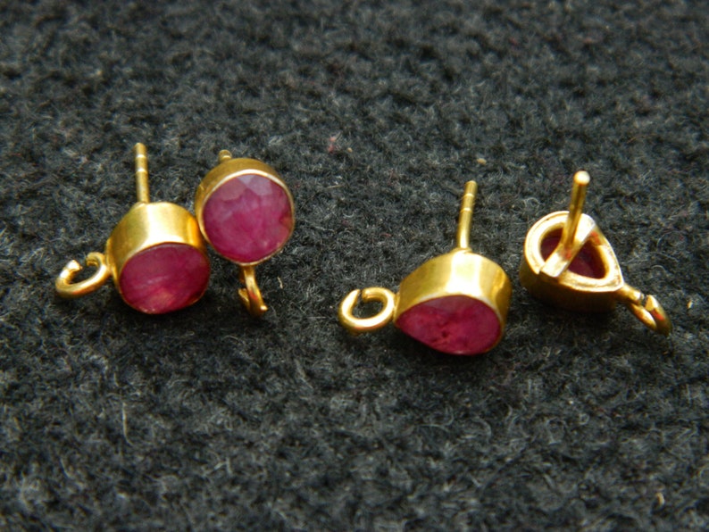 Pu&ograve; includere: Tre montature per orecchini in oro con accenti di pietre preziose rosse. Le montature hanno un anello a un'estremit&agrave; e un perno all'altra.