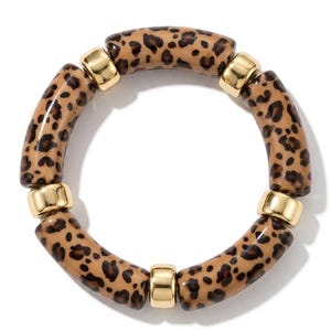 Può includere: Un bracciale elastico circolare caratterizzato da perline cilindriche alternate con un motivo leopardato marrone chiaro e nero e perline distanziatrici in metallo dorato liscio e lucido disposte in una sequenza ripetitiva.