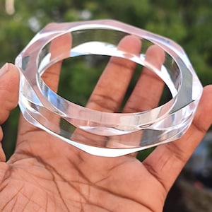 Puede incluir: Pulsera geom&eacute;trica transparente de acr&iacute;lico. La pulsera tiene un dise&ntilde;o multifac&eacute;tico que refleja la luz. El material transparente permite ver la piel debajo. Un accesorio elegante.