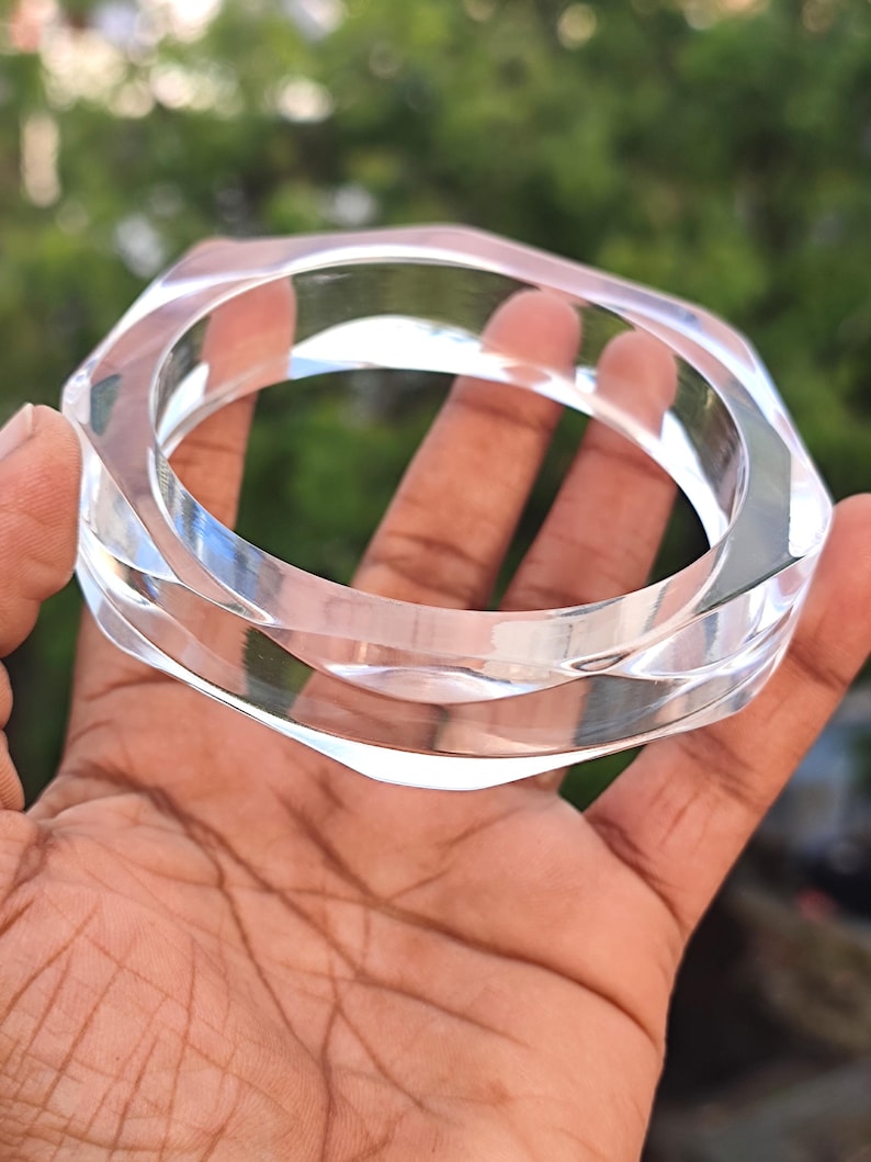 Puede incluir: Pulsera geom&eacute;trica transparente de acr&iacute;lico. La pulsera tiene un dise&ntilde;o multifac&eacute;tico que refleja la luz. El material transparente permite ver la piel debajo. Un accesorio elegante.