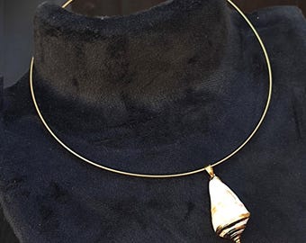 May include: A gold choker necklace with a white and brown seashell pendant.