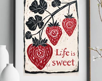 May include: A black framed print with a white background featuring a red and black illustration of strawberries on a vine. The text "Life is sweet" is printed in red below the strawberries.