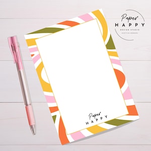 May include: A blank white notepad with a colourful abstract design border. The border features pink, orange, yellow, and green stripes. The notepad has a gold border and the text "Paper Happy" at the bottom.