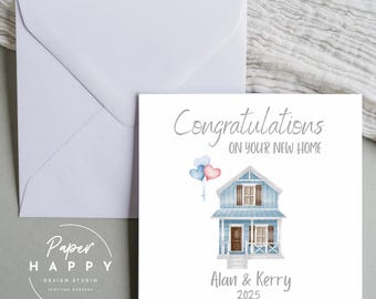 Puede incluir: Una tarjeta blanca con una ilustración de una casa azul y el texto "Felicidades por su nuevo hogar". Los nombres "Alan & Kerry" y el año "2025" están impresos debajo de la casa. Dos globos en forma de corazón flotan sobre la casa.