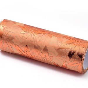 May include: A roll of orange wrapping paper with a metallic gold leaf pattern.