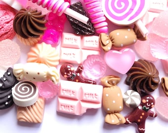 May include: A collection of assorted candies in shades of pink, brown, and white. The image includes lollipops, chocolate bars, cookies, and other sweet treats. The candies are arranged in a random pattern.