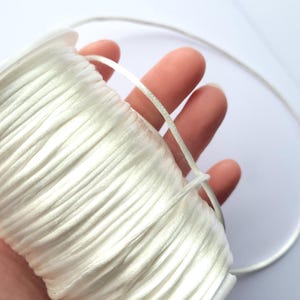 May include: A spool of white waxed cord, ideal for jewellery making or crafts.