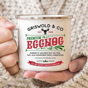 May include: White enamel mug with a red and green design. The mug says "Griswold & Co. Est. 1989 Premium Eggnog" and "Nobody's walking out on this fun, old-fashioned family Christmas!"