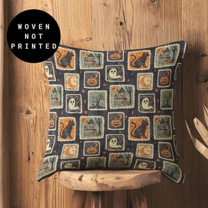 May include: Square cushion with a Halloween design. The dark blue cushion has a repeating pattern of stamps featuring black cats, haunted houses, pumpkins, ghosts, and moons. The text "WOVEN NOT PRINTED" is in a black circle.